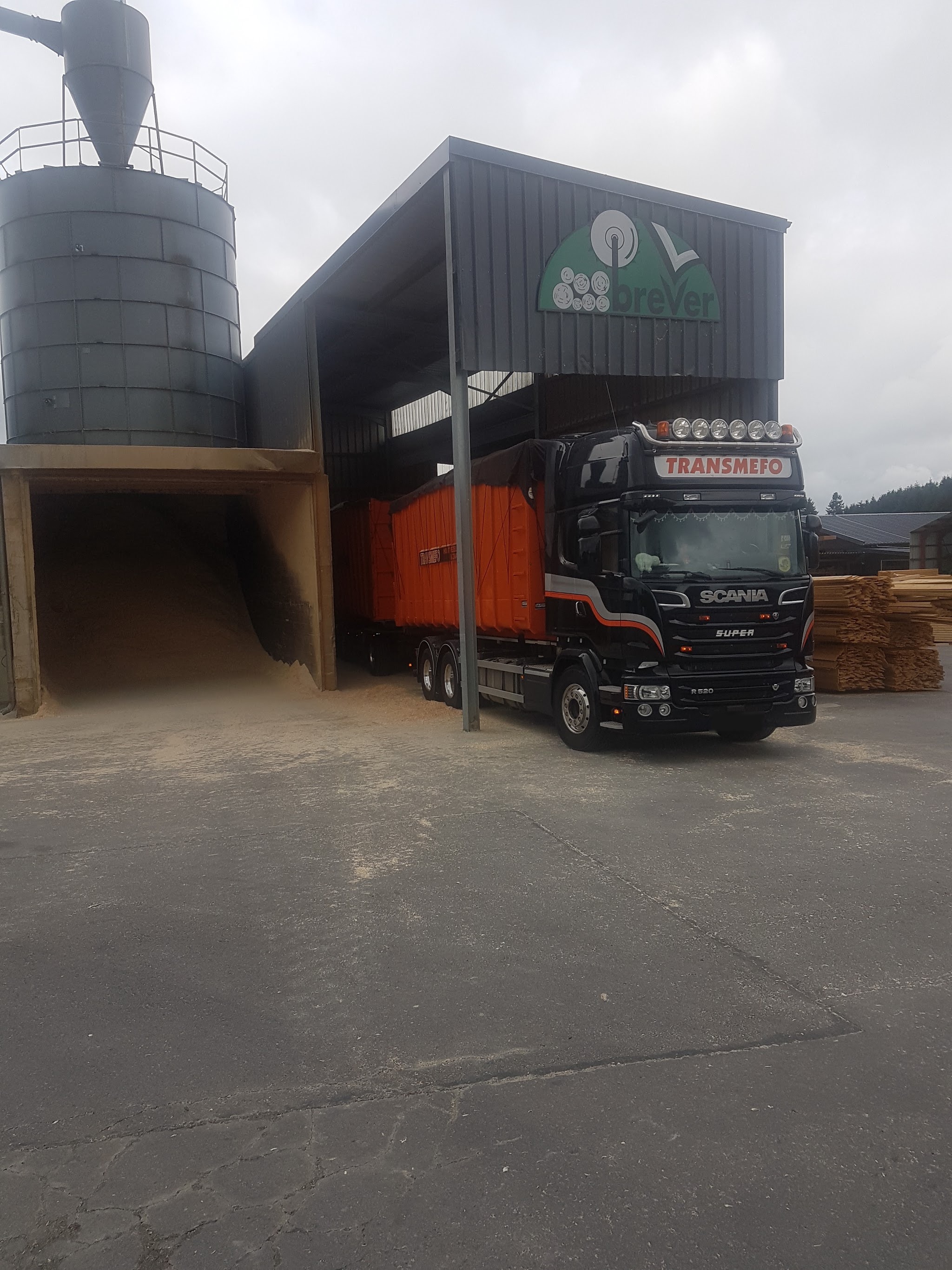 Scania TRANSMEFO met oranje container onder een overkapping met silo